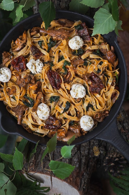 Tagliatelle-Nudeln mit Pfifferlingen, Spinat, sonnengetrockneten Tomaten und Mozzarella