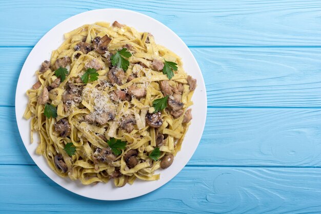 Tagliatelle de pasta con carne de pollo y champiñones comida italiana