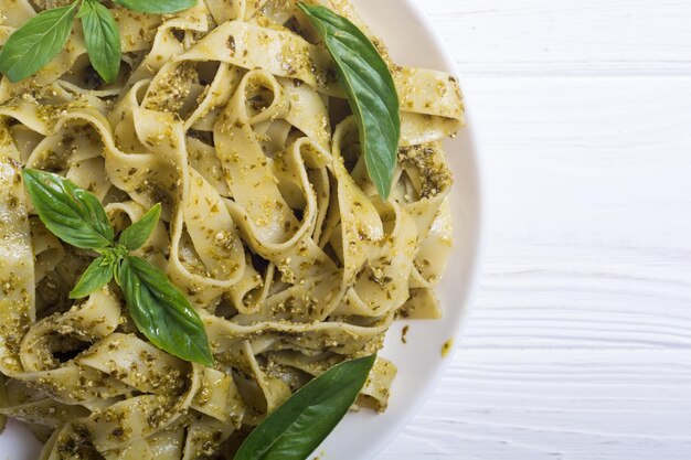 Tagliatelle de pasta con salsa verde pesto fondo de comida italiana