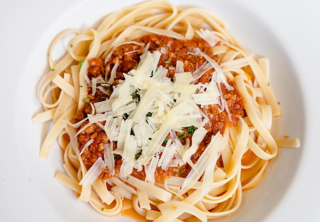 Tagliatelle plato boloñés con queso parmesano rallado vista desde arriba. Comida tradicional italiana