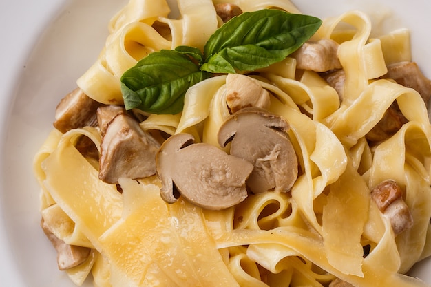 Tagliatelle vegetarische Pasta Dish mit Pilzen mit Basilikum dekoriert.