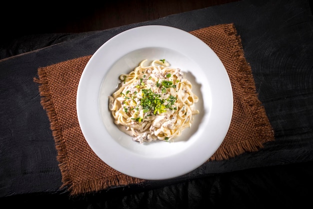 Tagliatelli de carne sobre tela marrón y vista superior de madera negra