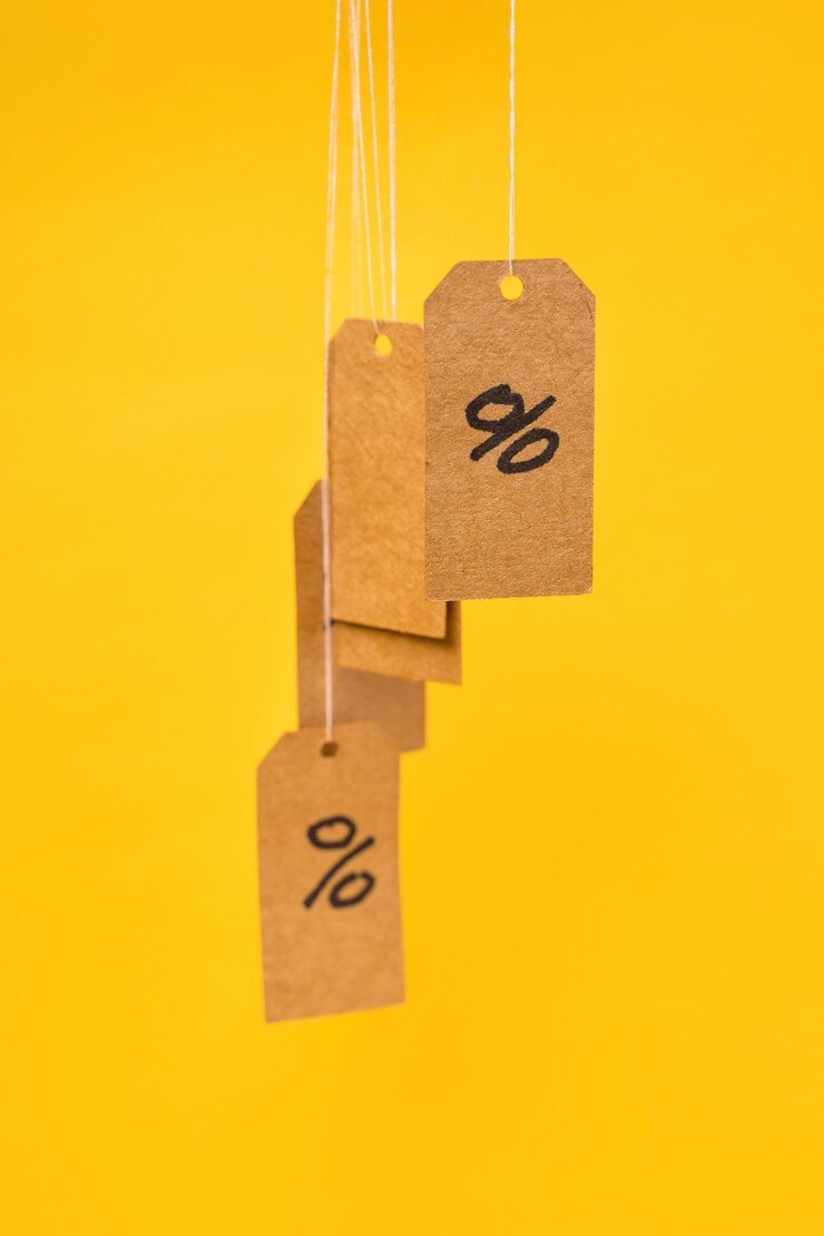 Foto tags com porcentagens desenhadas penduradas em cordas em um fundo amarelo, conceito de descontos e vendas