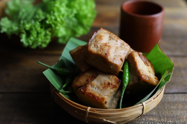 Tahu Bacem ist traditionelles Essen aus Java Indonesien, das auf dem Holzteller mit Bananenblatt serviert wird