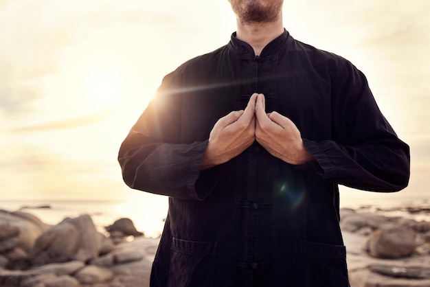 Tai-Chi-Kampfkunst und Mann mit Händen am Strand für Fitness und Meditation balancieren Energie und Heilung bei Sonnenaufgang mit Selbstverteidigungsübung Ruhiger Frieden und Zen-Karate und Wellness im Freien