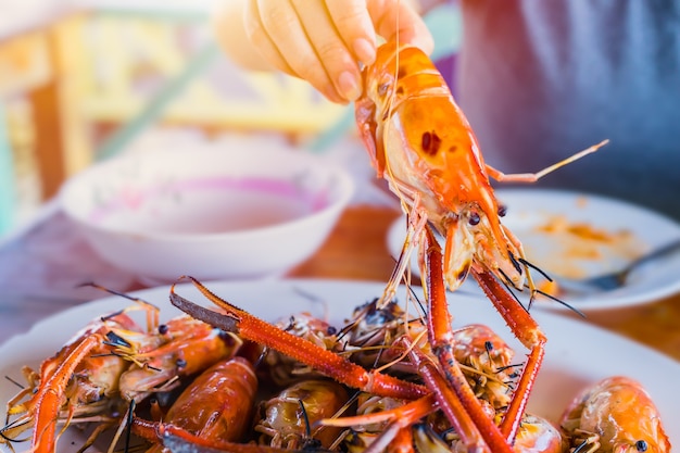 Los tailandeses asiáticos comen camarones de camarones de río gigantes a la parrilla con salsa picante de mariscos agridulces y deliciosa comida popular en Tailandia.