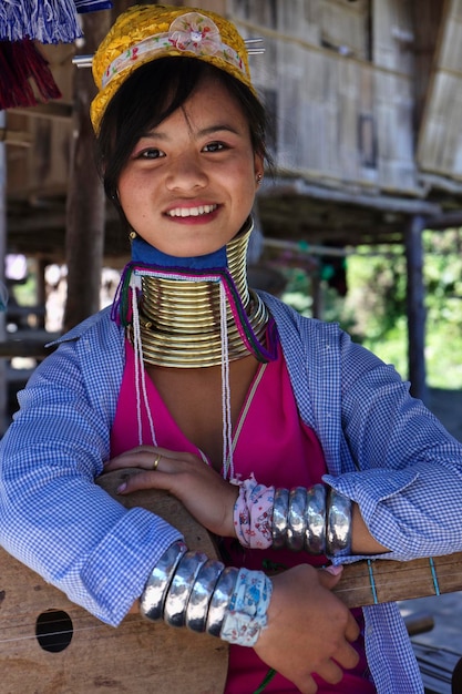Foto tailândia, chiang mai, karen long neck hill tribo village (baan tong lhoung), mulher long neck em trajes tradicionais. as mulheres colocam anéis de latão no pescoço aos 5 ou 6 anos e aumentam
