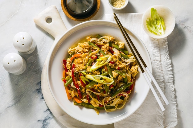 Tailandia comida callejera - Pad Thai con tofu en un plato sobre una mesa, en un restaurante o cafetería