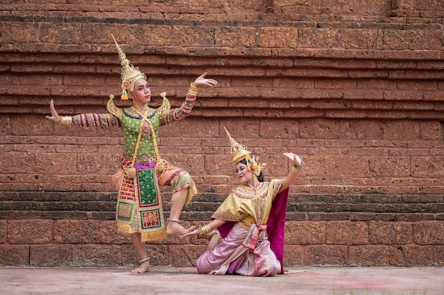 Tailandia Pareja de baile en representaciones de Khon enmascarado con templo antiguo