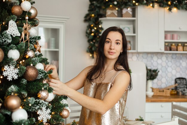 Taille der lächelnden hübschen Frau, die Weihnachtsbaum verziert