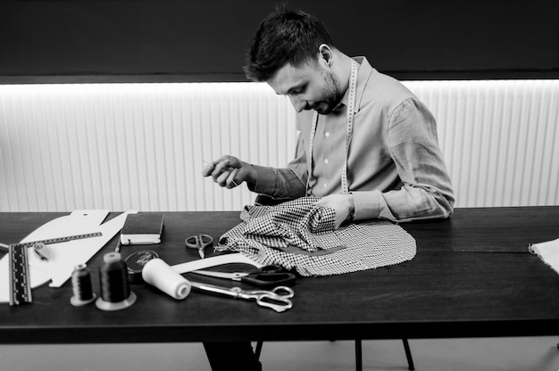 Tailor cose un traje en el taller