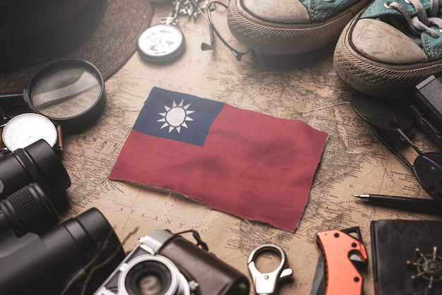 Taiwan-Flagge zwischen dem Zubehör des Reisenden auf alter Weinlese-Karte. Touristisches Bestimmungsort-Konzept.