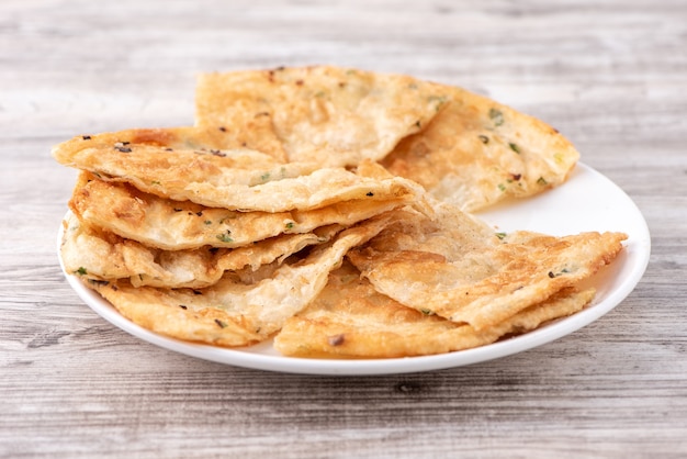 Taiwanesisches Essen - köstliche Pfannkuchen mit Frühlingszwiebelkuchen auf hellem Holztischhintergrund