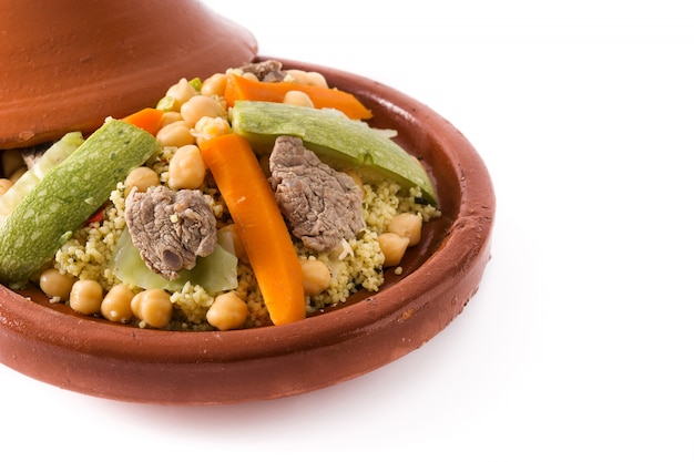 Tajine tradicional com legumes, grão de bico, carne e cuscuz isolado na superfície branca