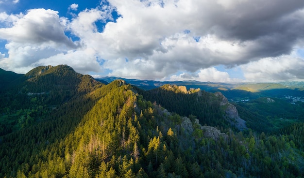 Tal der balkanberge mit nebel, sonnigen wolken und walddorf pamporovo panorama draufsicht