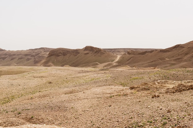 Tal in der Judäischen Wüste mit einer Straße am Horizont in Israel
