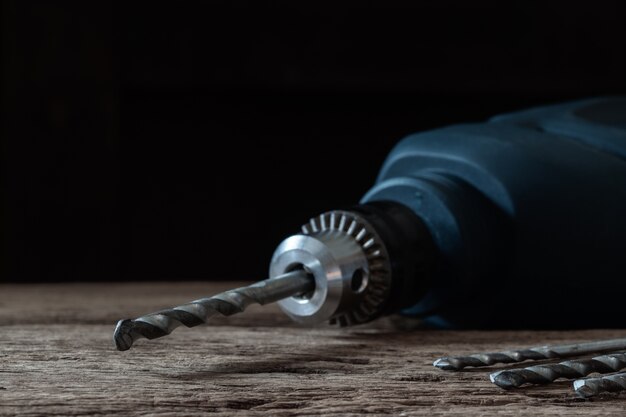 Taladro y conjunto de taladro en mesa de madera, herramientas de carpintero, concepto de reparación de inicio