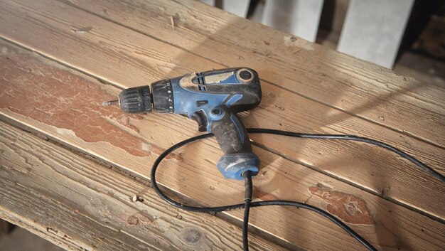 Taladro eléctrico en la mesa de madera