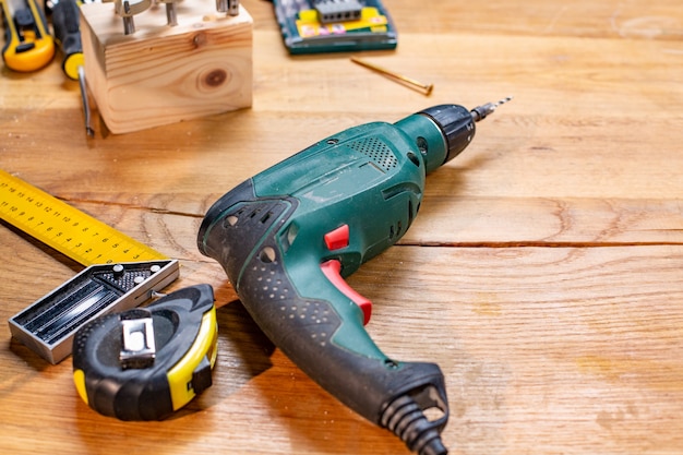 Taladro de taller de carpintería y otras herramientas sobre la mesa