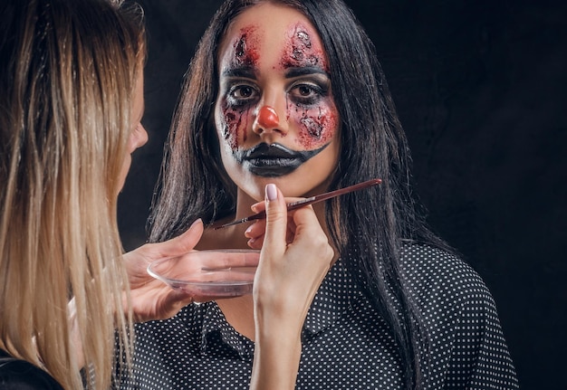 Talentierter Make-up-Künstler kreiert spezielle gruselige Halloween-Kunst auf dem Gesicht der Frau.