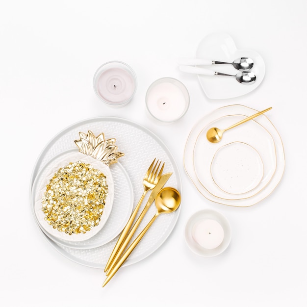 Foto talheres e decorações para servir uma mesa festiva. pratos, taças de vinho e talheres com velas em fundo branco.