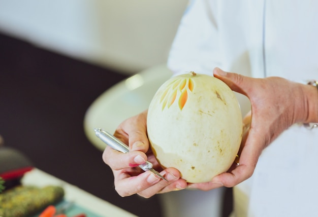 Talla de fruta tailandesa con mano, talla de verduras y frutas.