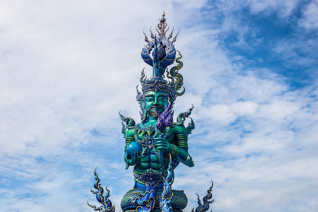 Talla de poste del cuento de hadas artístico en el templo de Wat Rong Sua Ten con fondo de cielo azul