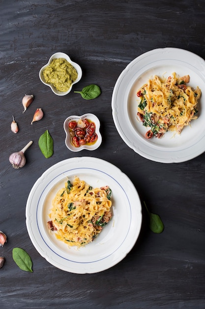 Tallarines de boniato de pasta italiana con tocino, tomates secos y espinacas