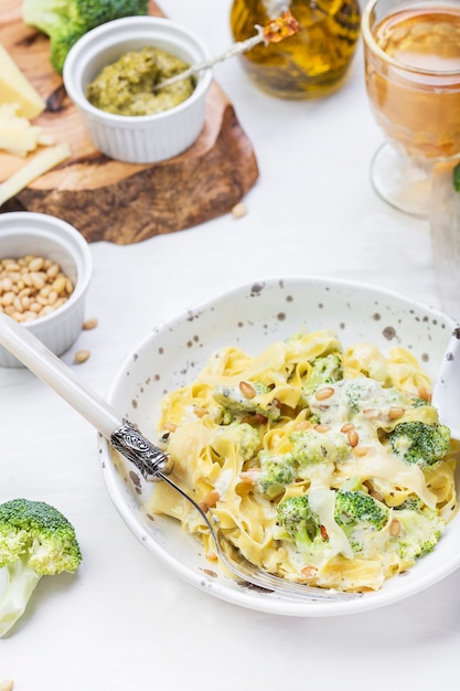 Tallarines caseros de pasta de calabaza con brócoli y pesto en salsa cremosa