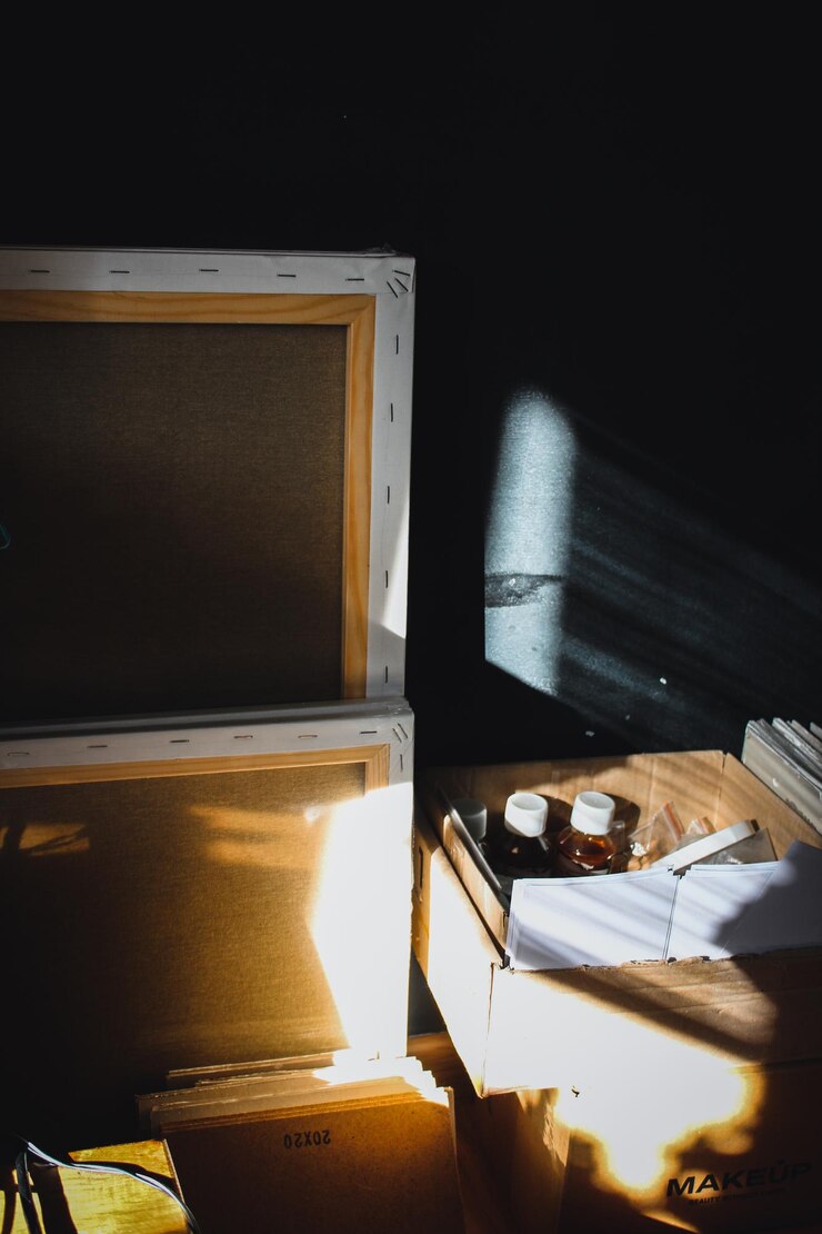Taller del artista Lienzos y cajas con pintura sobre el fondo de una pared negra