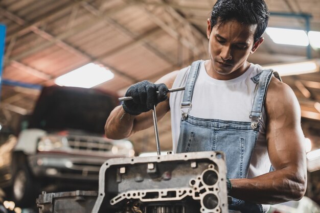 Taller de automóviles y estación de mantenimiento de automóviles concepto técnico mecánico automotriz que trabaja en la parte de la tienda del vehículo y la herramienta de combustión de aceite