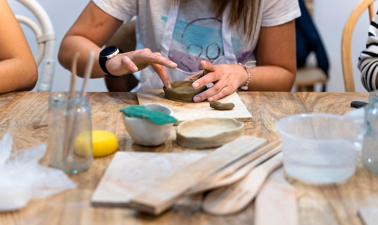 Foto taller de cerámica primer plano de las manos de una mujer trabajando con arcilla