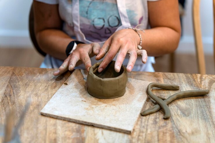 Foto taller de cerámica primer plano de las manos de una mujer trabajando con arcilla