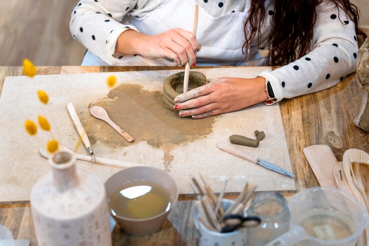 Foto taller de cerámica primer plano de las manos de una mujer trabajando con arcilla
