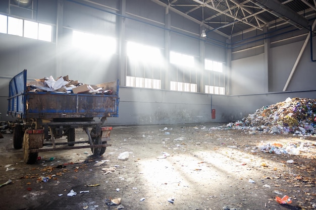 Foto taller de clasificación y reciclaje de basura con remolque en la planta de procesamiento de residuos con rayos de sol recolección separada de basura reciclaje y almacenamiento de residuos para su posterior eliminación