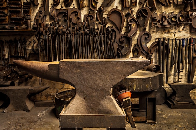 Foto taller de herramientas de metal y yunque en forja con fondo de pared para la fabricación o el desarrollo de la industria espacio de trabajo de fábrica retro o industrial para hierro de acero o producto con artesanía vintage