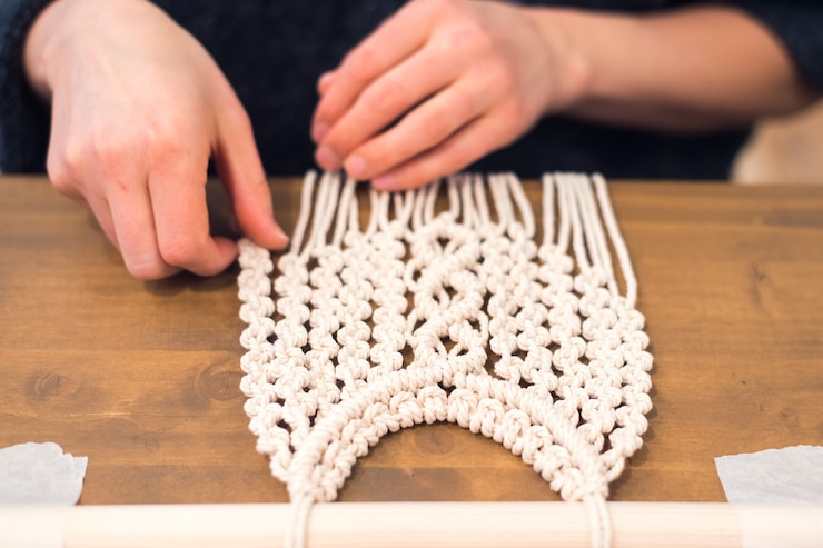 Foto taller de macramé mujer tejiendo paneles de macramé para decoración del hogar