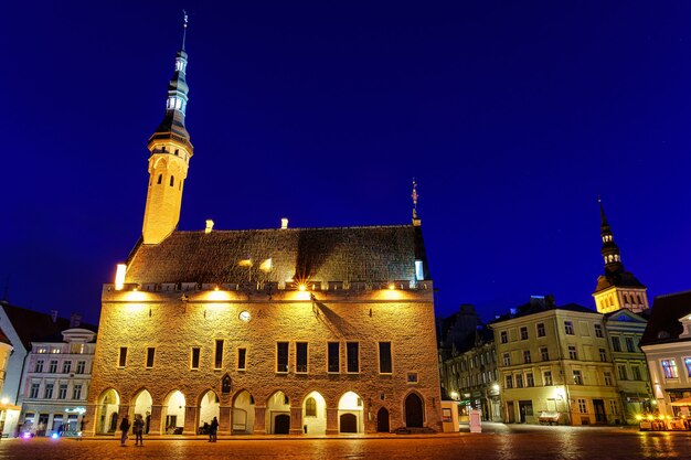 Tallinn Town Hall Square iluminada à noite após a chuva.