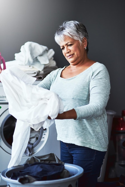 Foto talvez precise de outra rodada de lavagem foto de uma mulher madura lavando roupa em casa