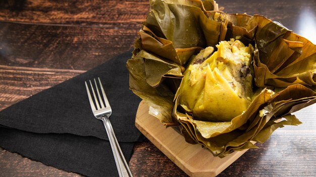 Tamal una de las comidas tradicionales de colombia sobre fondo de madera