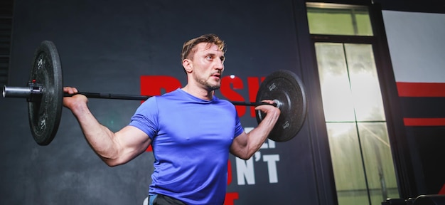 Tamanho do banner Ajuste jovem levantando peso malhando em um conceito de musculação de treino de músculos de academia