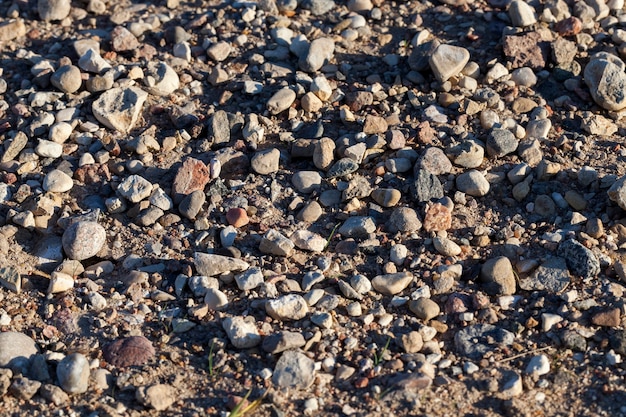 Tamanhos diferentes, mas todas pequenas pedras na estrada na areia
