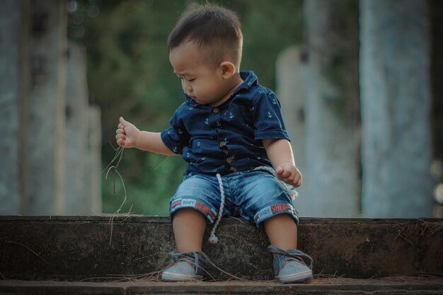 Foto el tamaño completo de un bebé lindo sentado en los escalones