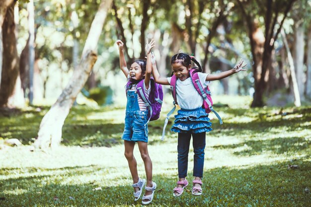 El tamaño completo de las colegialas saltando en el parque