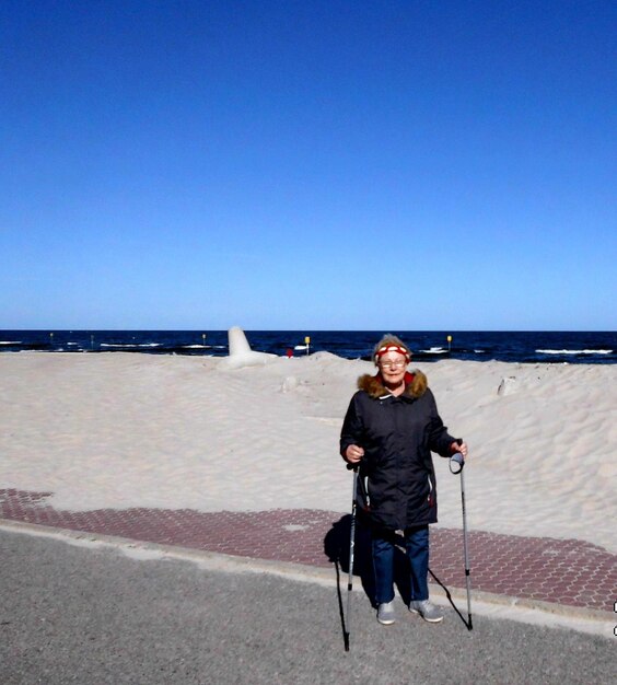 El tamaño completo de un hombre en la playa contra un cielo despejado