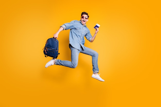 Tamaño de cuerpo entero convertido en foto de hombre gritando corriendo saltando hacia el aeropuerto con zapatos blancos y cartera en manos aisladas pared de color amarillo vivo