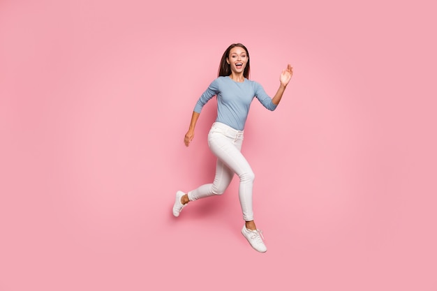 Tamaño de cuerpo entero convertido en foto de mujer casual de moda positiva corriendo hacia el sueño en calzado que expresa emoción en la cara aislada fondo de color rosa pastel