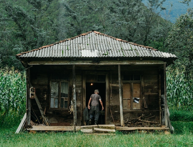 Foto el tamaño total del hombre fuera de la casa