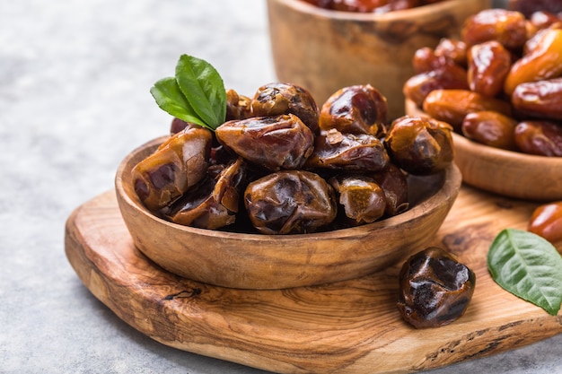 Tâmaras ou dattes da fruta da palma em uma tigela de madeira