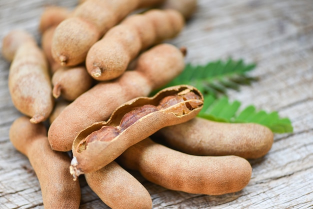 Tamarindo e folhas de frutas tropicais - tamarindo doce em fundo de madeira